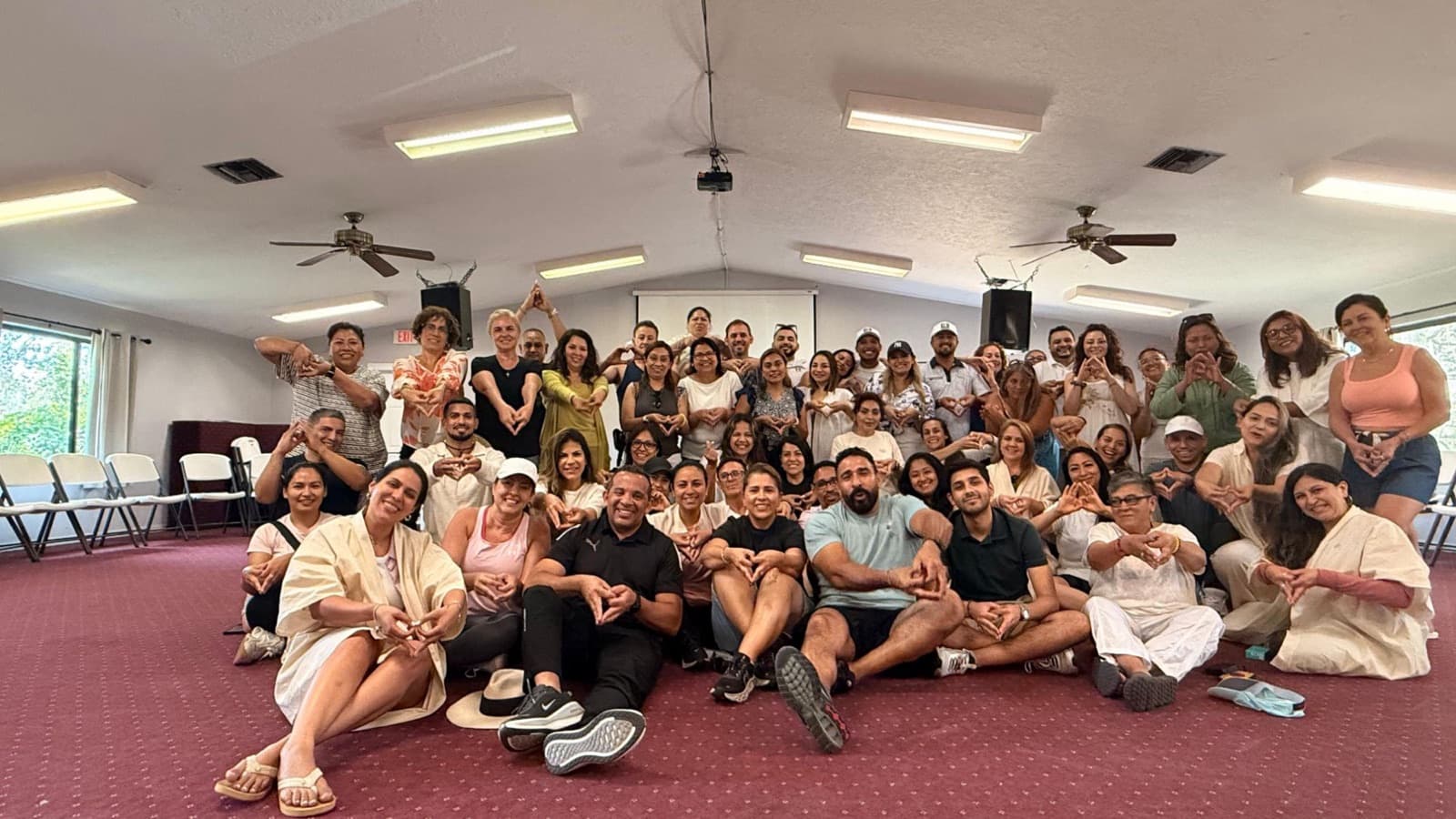 Jairo J. García and event participants making a heart shape together with their hands