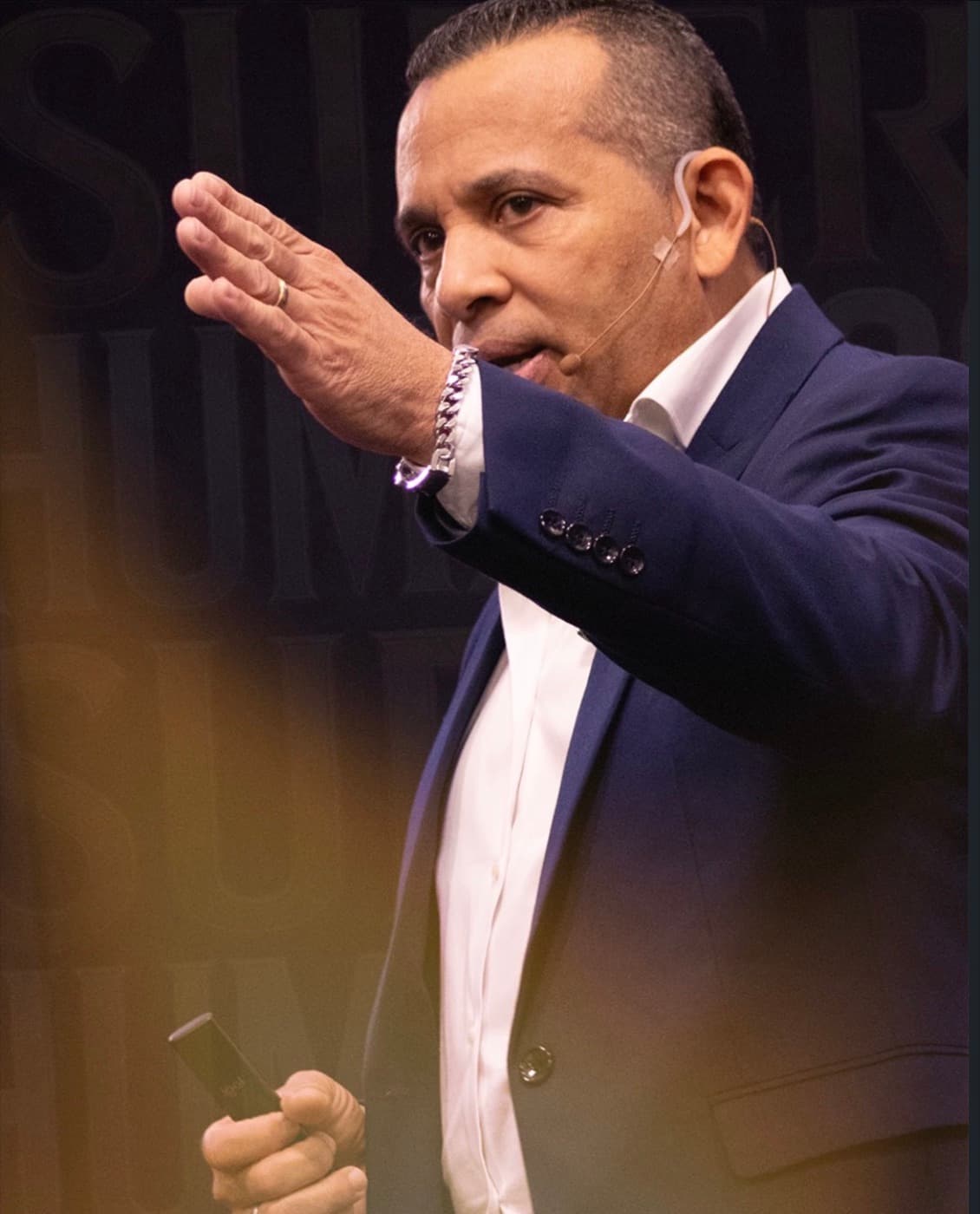 Jairo J. García during a keynote, wearing a headset microphone, in front of a Superhumanos backdrop
